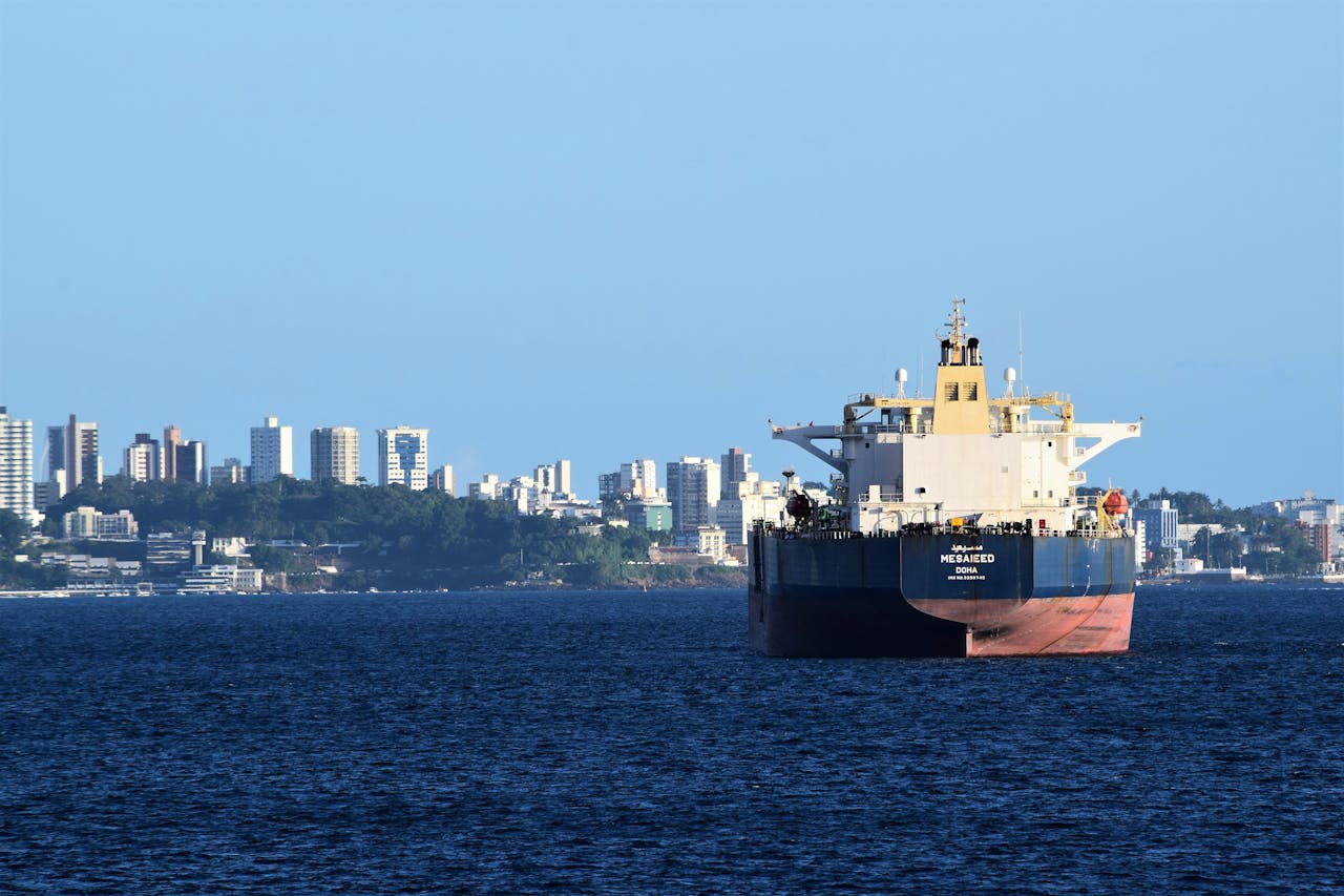 A cargo ship anchored in Salvador, Brazils harbor with the city skyline in the backdrop.